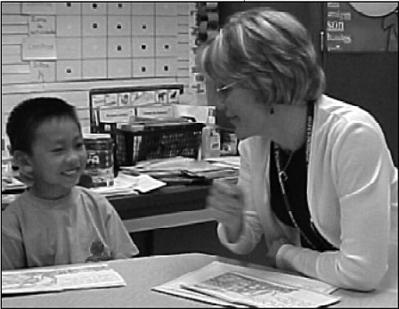 First-grade teacher Jodie Hall works with an emerging reader at 
					Nitrauer Elementary.
